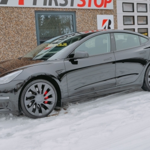 Tesla Model 3 med keramisk coating parkeret i snevejr med vand- og smudsafvisende lakbeskyttelse