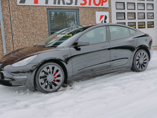 Tesla Model 3 med keramisk coating parkeret i snevejr med vand- og smudsafvisende lakbeskyttelse