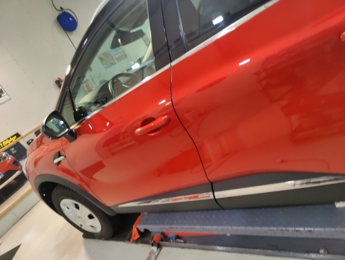 Rød bil klargjort til keramisk coating behandling i værksted